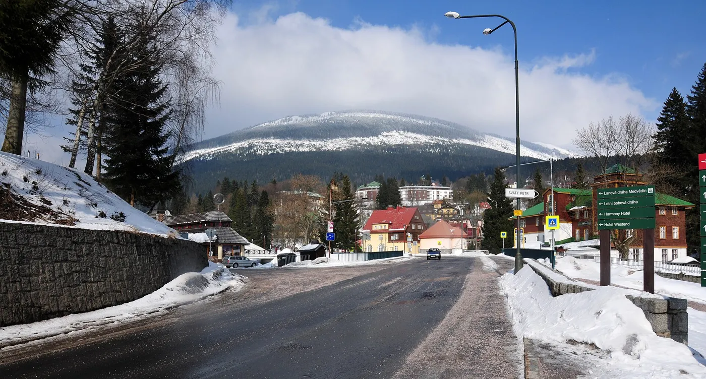 Zasněžená ulice ve Špindlerově Mlýně pod horami